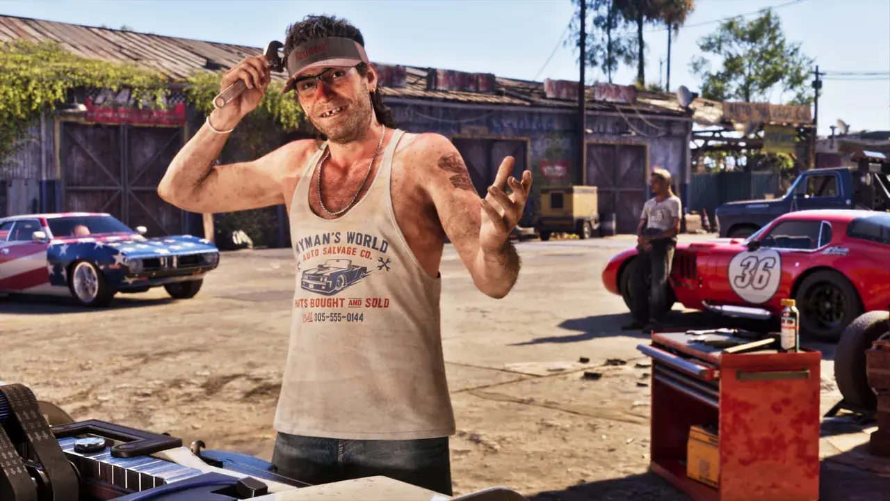 Wyman holds a wrench beside classic cars and workshop tools in a yard in GTA VI.