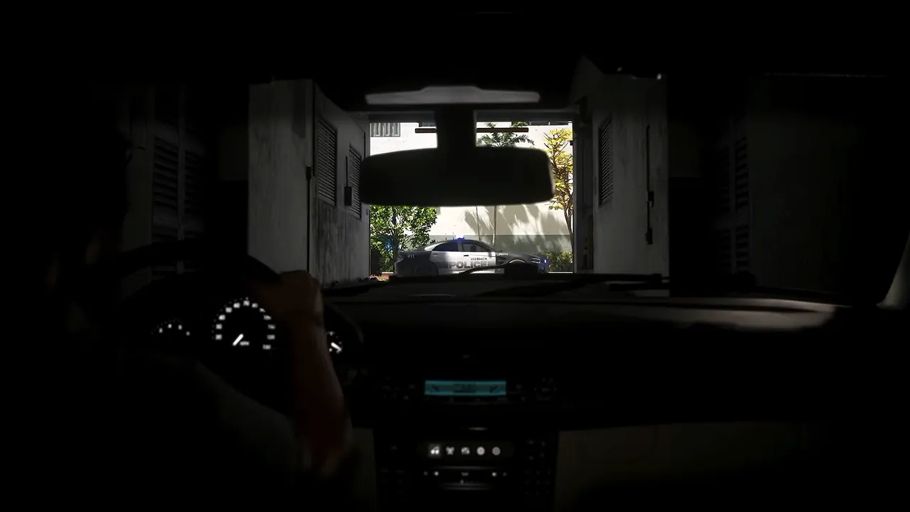 View from inside a dark garage, looking past a car’s dashboard toward a police car outside in GTA VI.